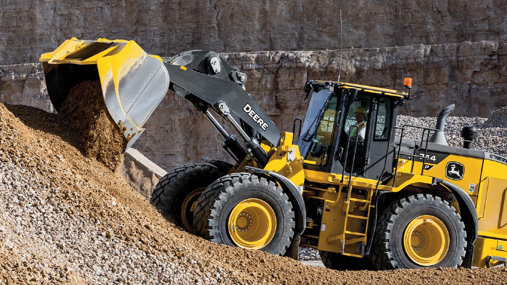 A wheel loader dumps a bucket of rocks onto a pile