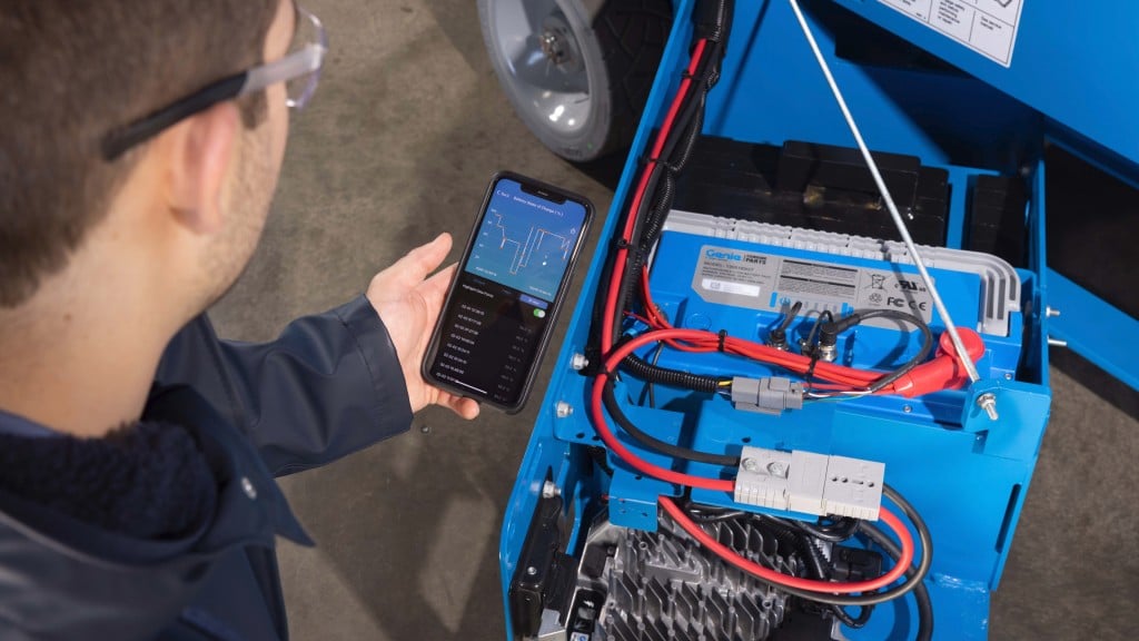 An operator checks the battery charge of a scissor lift