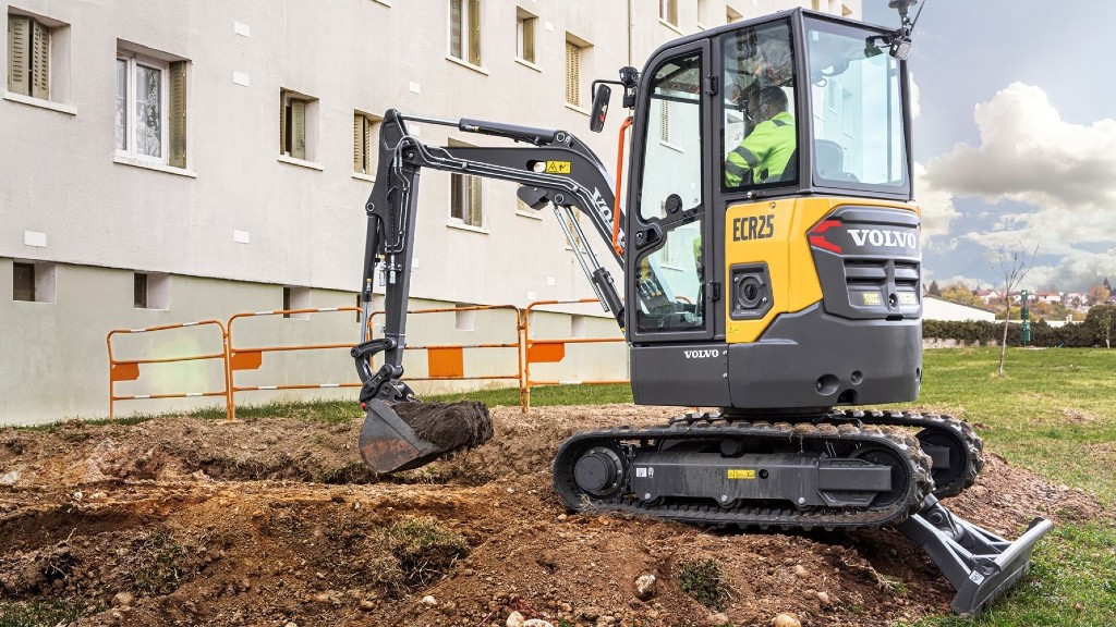 A compact excavator digs a hole on a job site