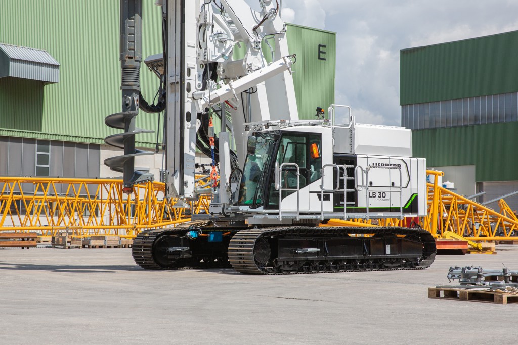 A drilling rig on a concrete pad near buildings