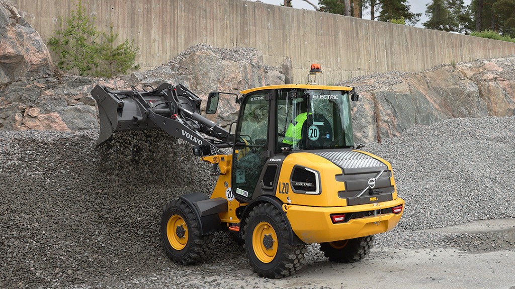 A compact wheel loader dumps rock material out of its bucket