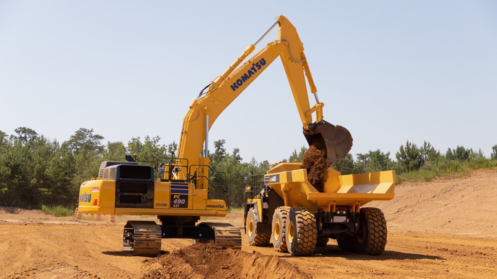 An excavator loads a truck with dirt