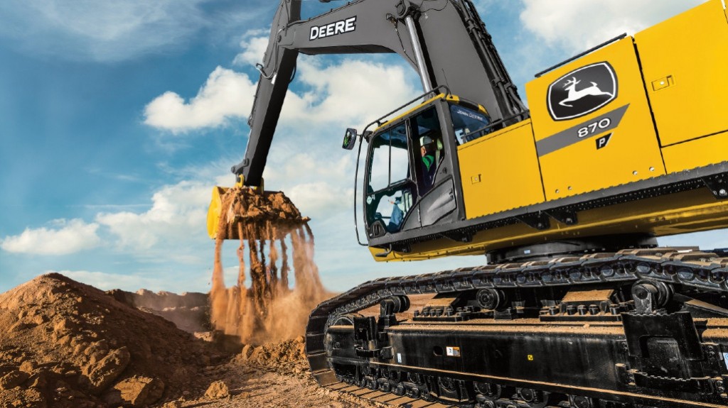 A John Deere excavator digs up dirt on a job site