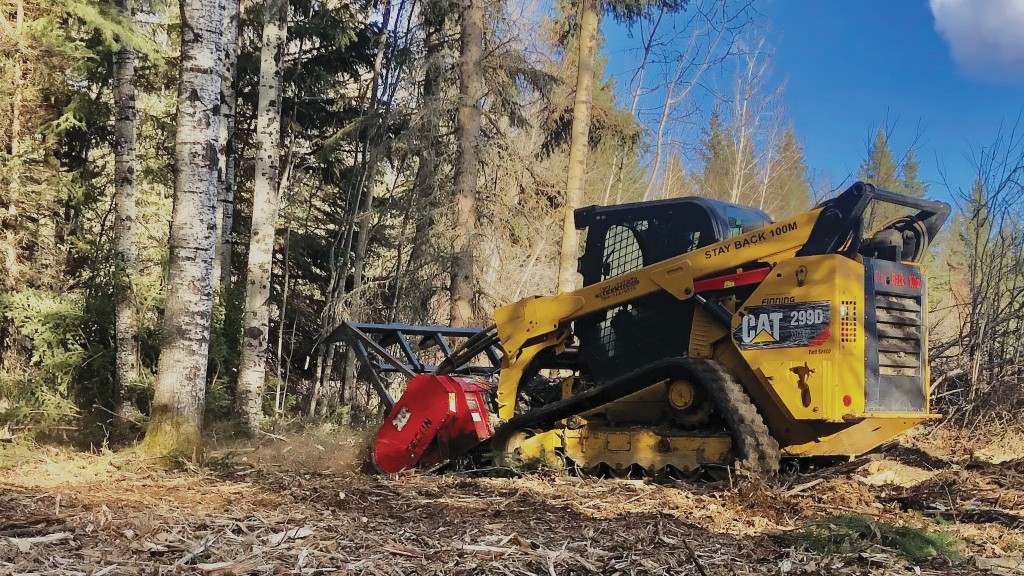 A compact track loader uses a mulcher on a job site