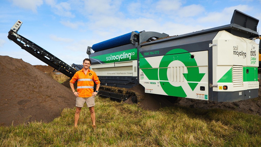 Somebody stands near a tracked trommel