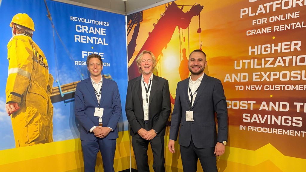 Three men standing in front of a trade show banner