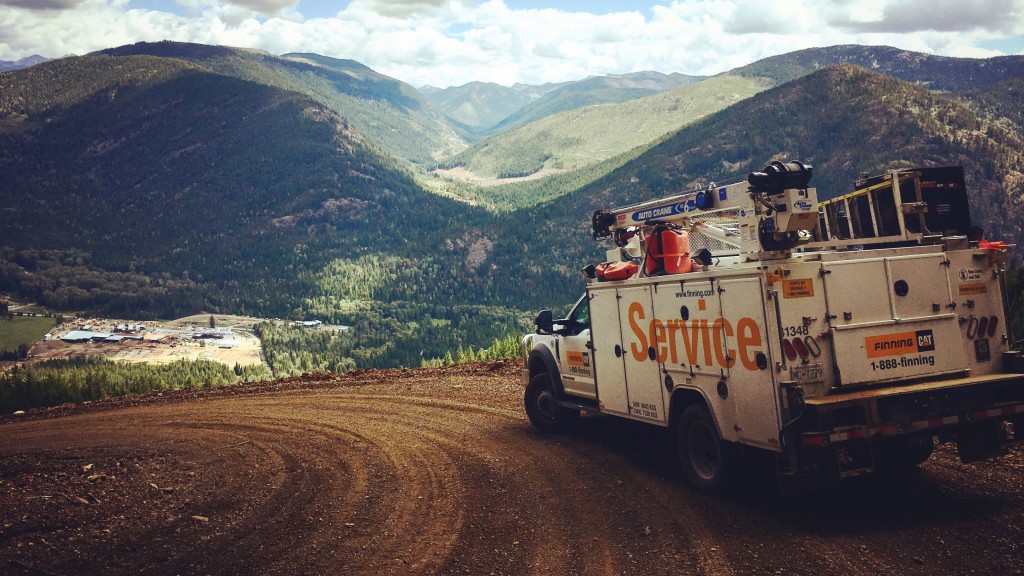 A service truck drives down a dirt hill