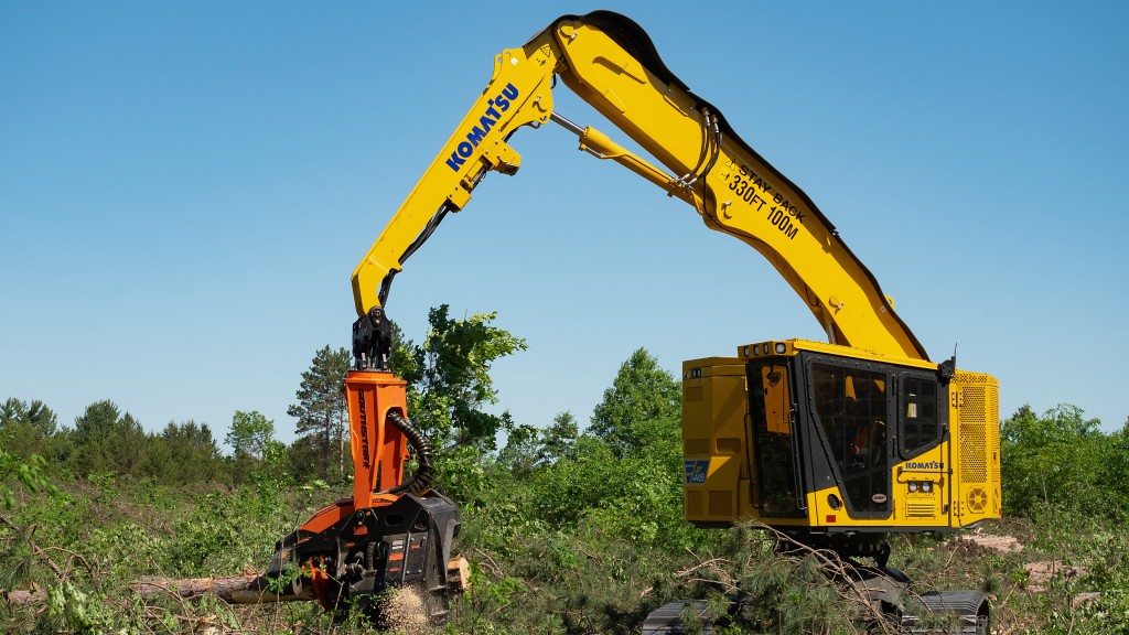 A tracked harvester harvests a tree on a forestry job site