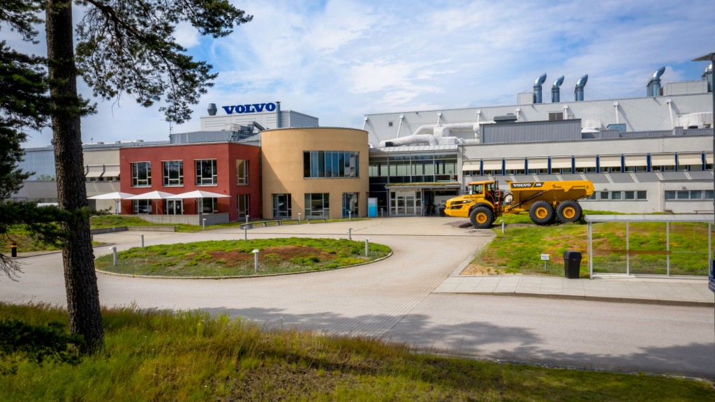 The front of a factory with an articulated dump truck near the door