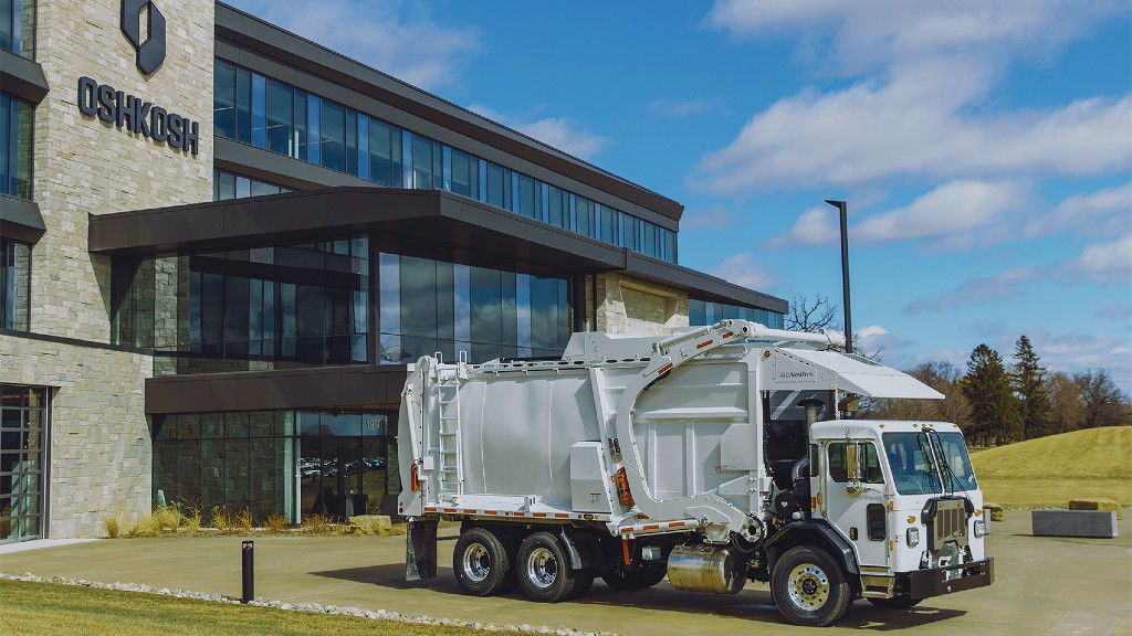 A collection truck is parked outside an office building