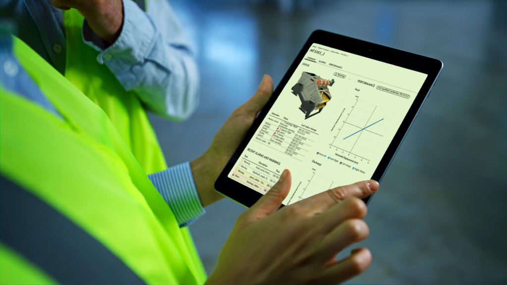 A man in a hi-vis vest looks at a tablet computer