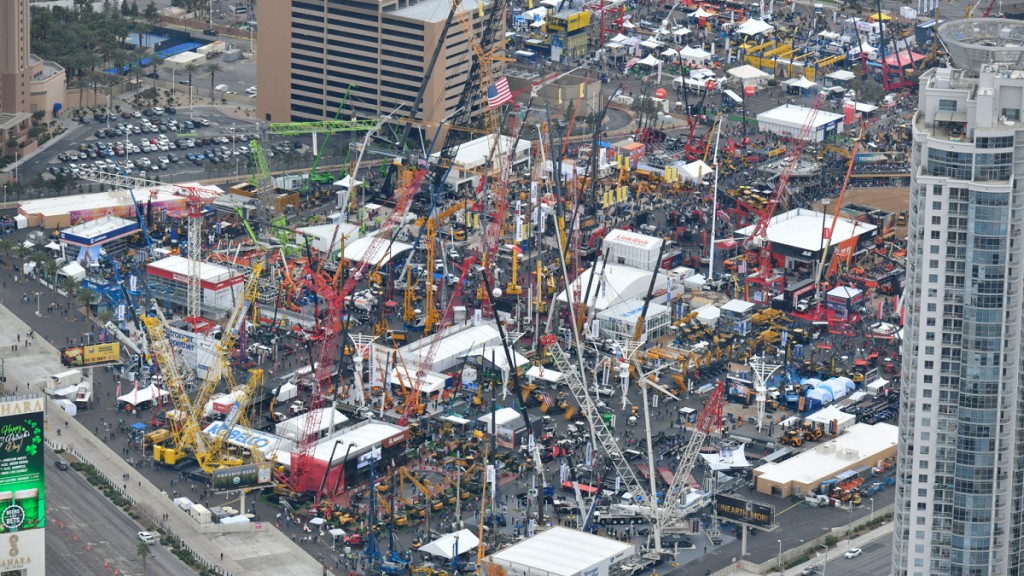 An aerial view of an outdoor trade show lot filled with cranes and equipment