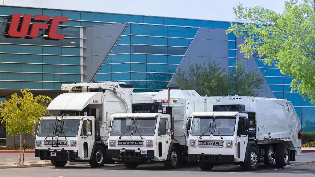 Three collection trucks are parked outside an office