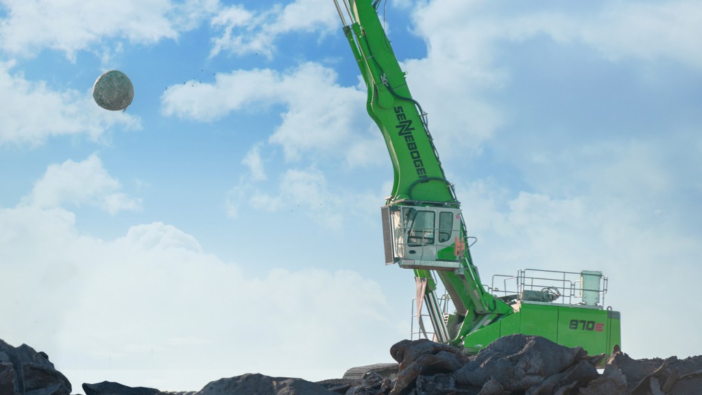 A material handler is parked on a job site near a truck