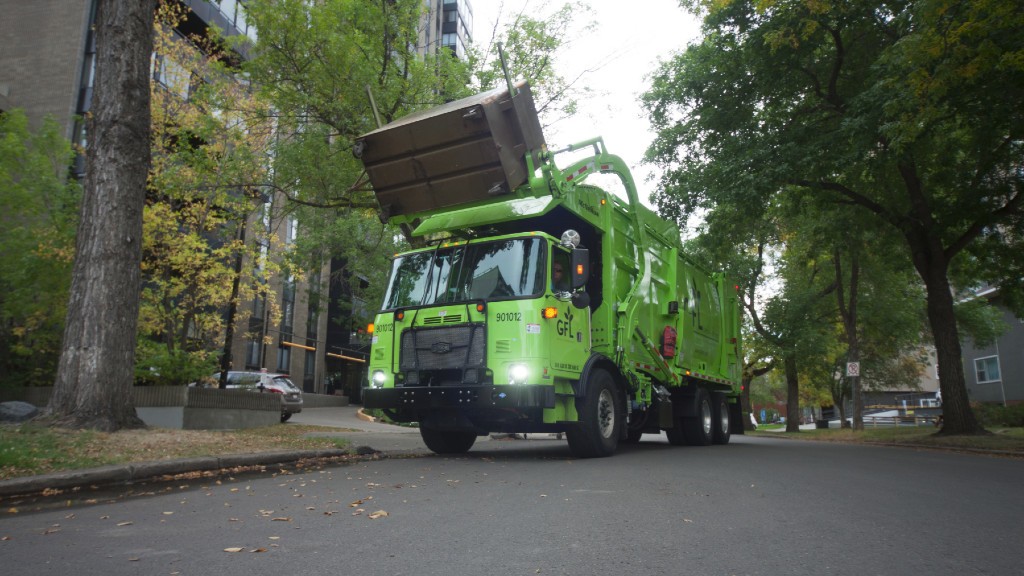 A collection truck picks up a dumpster on a residential road