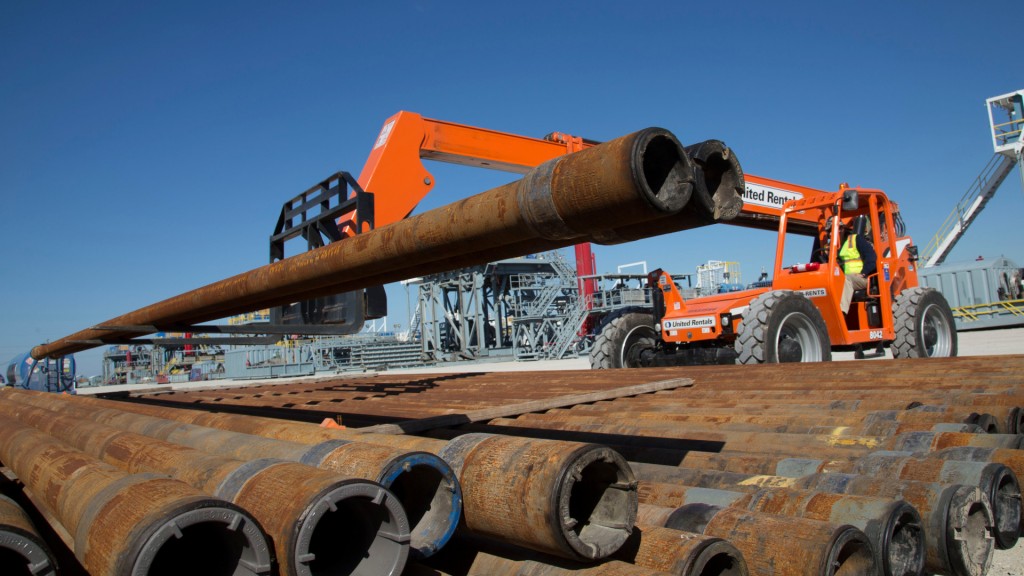 A telescopic handler picks up steel pipes