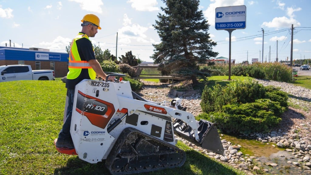 An operator operates a compact track loader