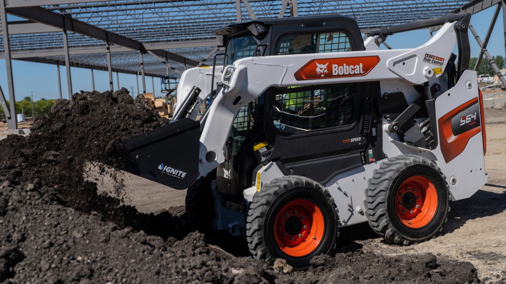 A skid steer loader using a bucket on a construction site.