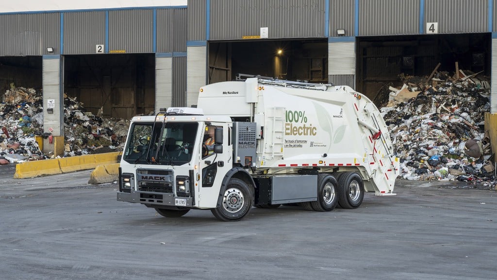 A collection truck is parked inside a waste facility