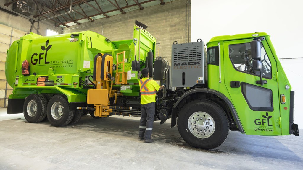 A collection truck is parked inside a building