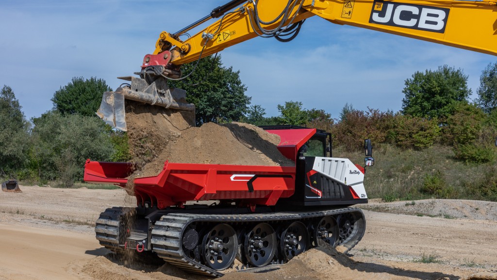 A tracked carrier being loaded by an excavator
