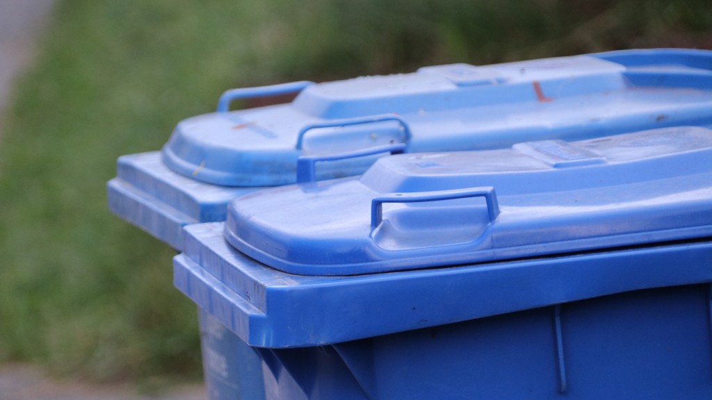 Two blue recycling bins on a curb