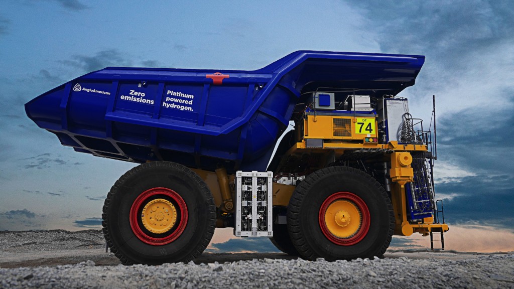 A blue and yellow haul truck on a mine road