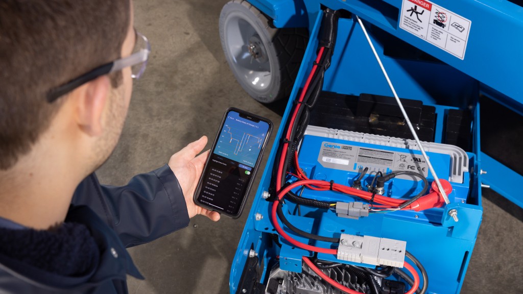 A technician works with a battery on lift equipment