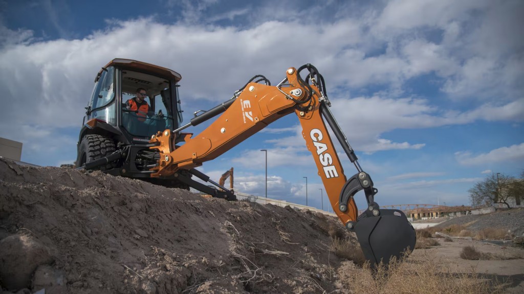 A backhoe loader operates near a ledge