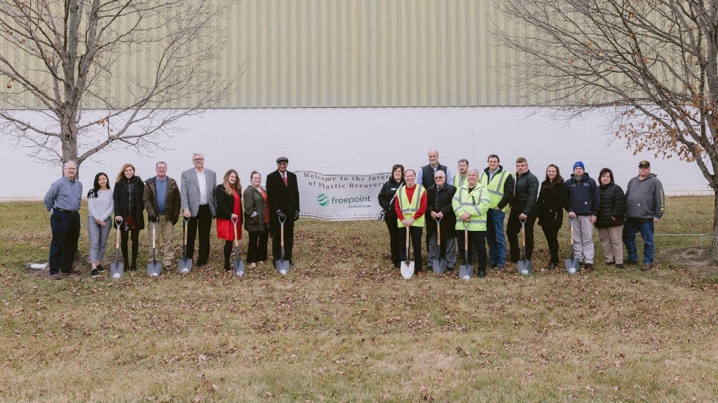 A group of people pose for a photo holding shovels