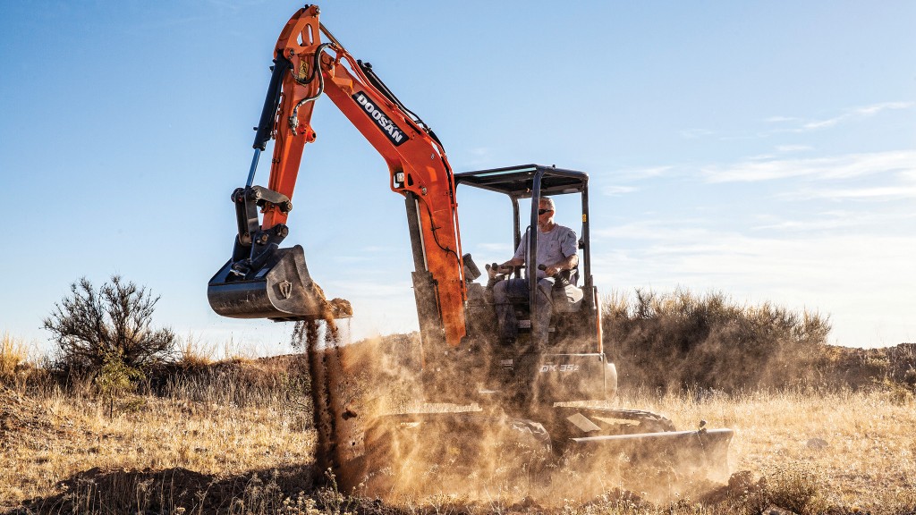 A mini excavator digs up dirt on a job site