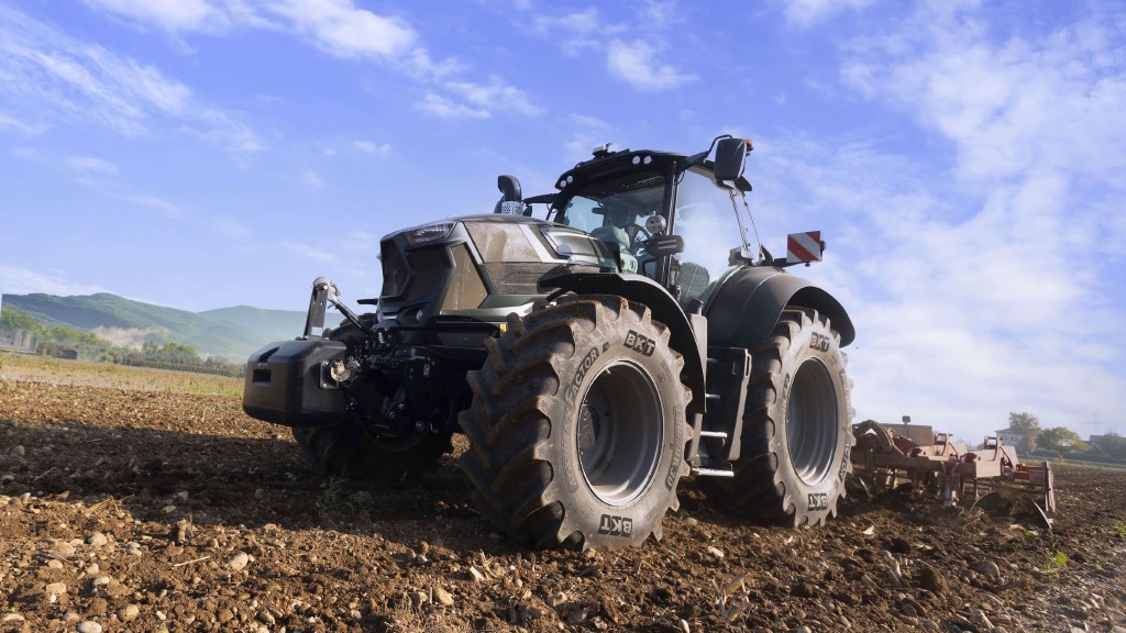 A tractor tills dirt on a farm