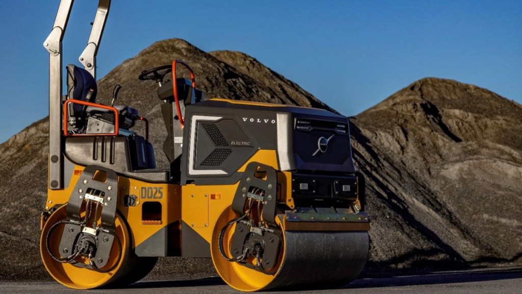 A double-drum compactor parked on a gravel job site.