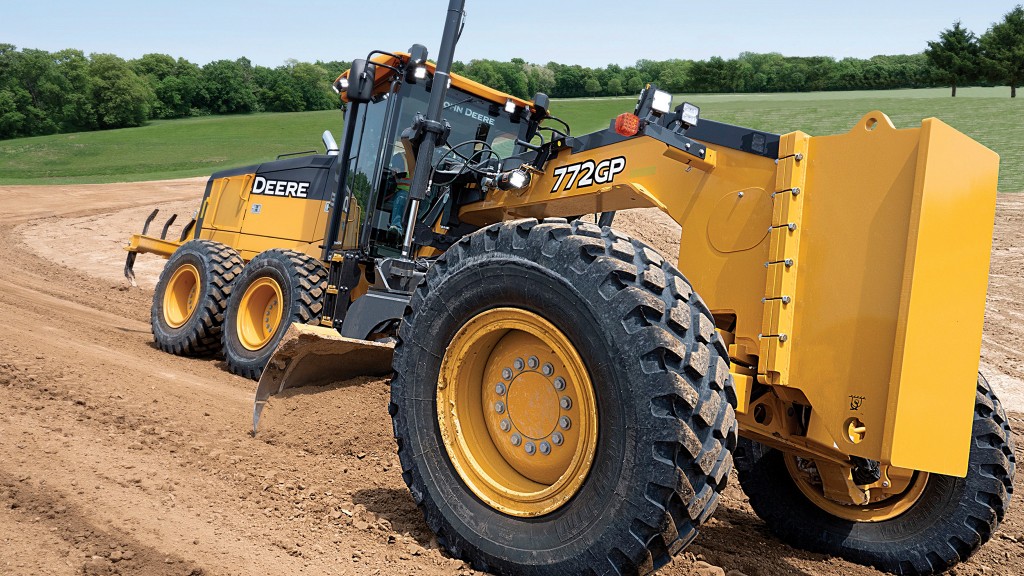 A motor grader smooths out a dirt surface