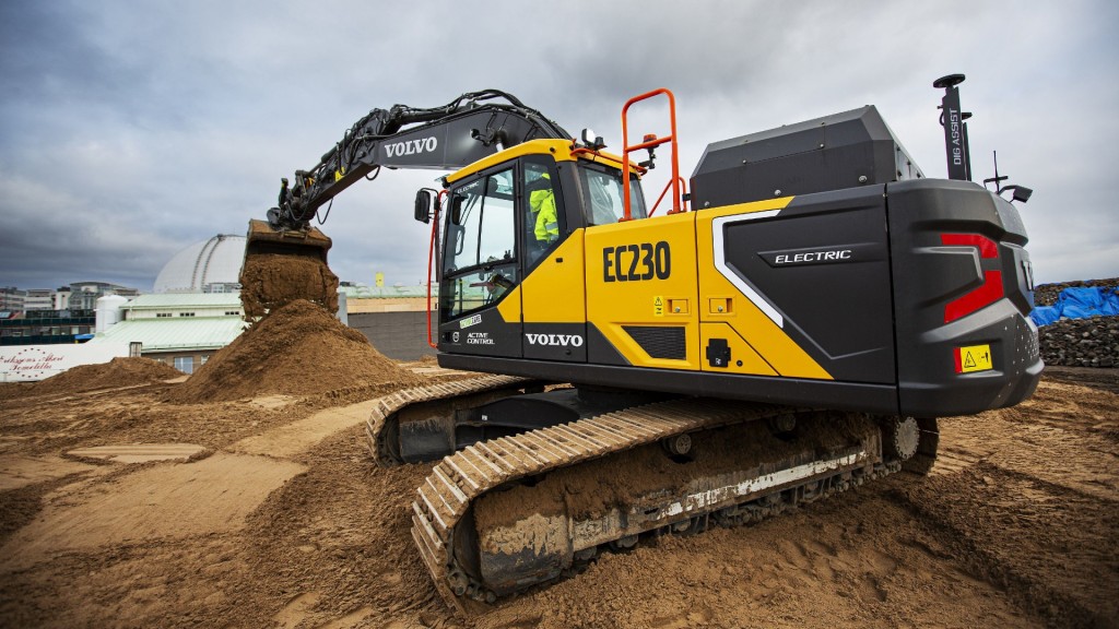 An electric excavator digging on a dirt pile