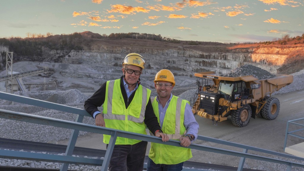 Two people pose for a photo on an aggregates job site