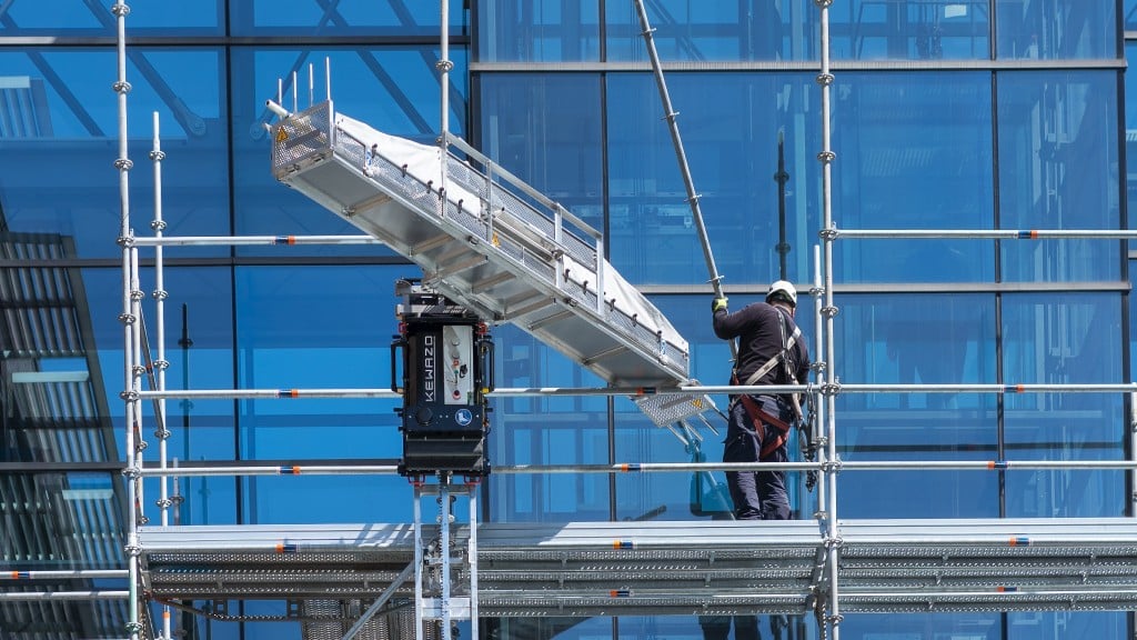 A robotic lift arm moves up scaffolding