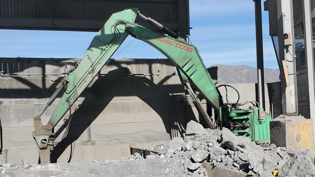 A rock breaker boom breaks rock on a job site