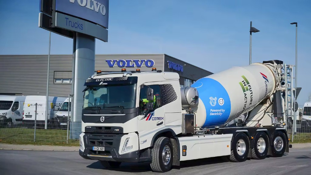 A concrete mixer truck is parked on the side of a road