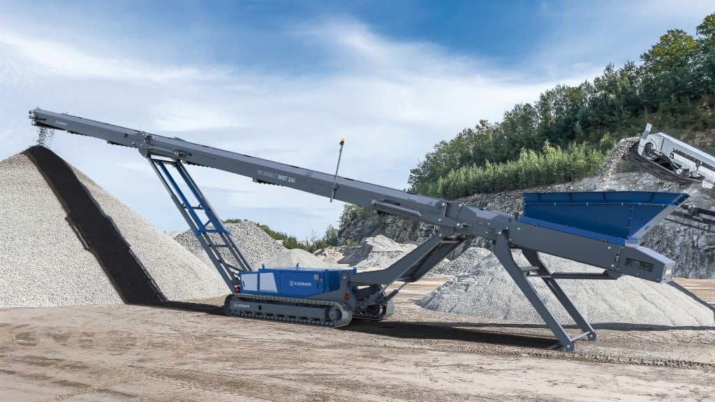 A stacker moves rock material onto a large pile