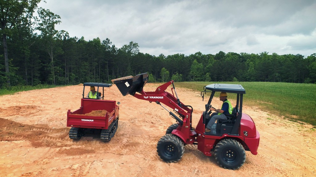 A compact wheel loader fills a tracked loader with dirt