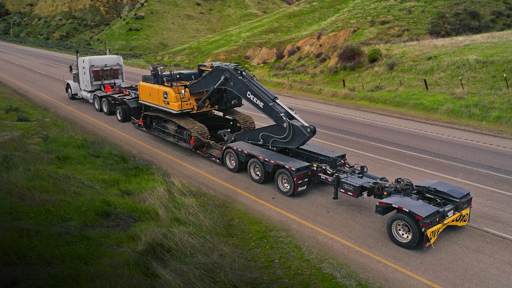A truck and trailer transport an excavator