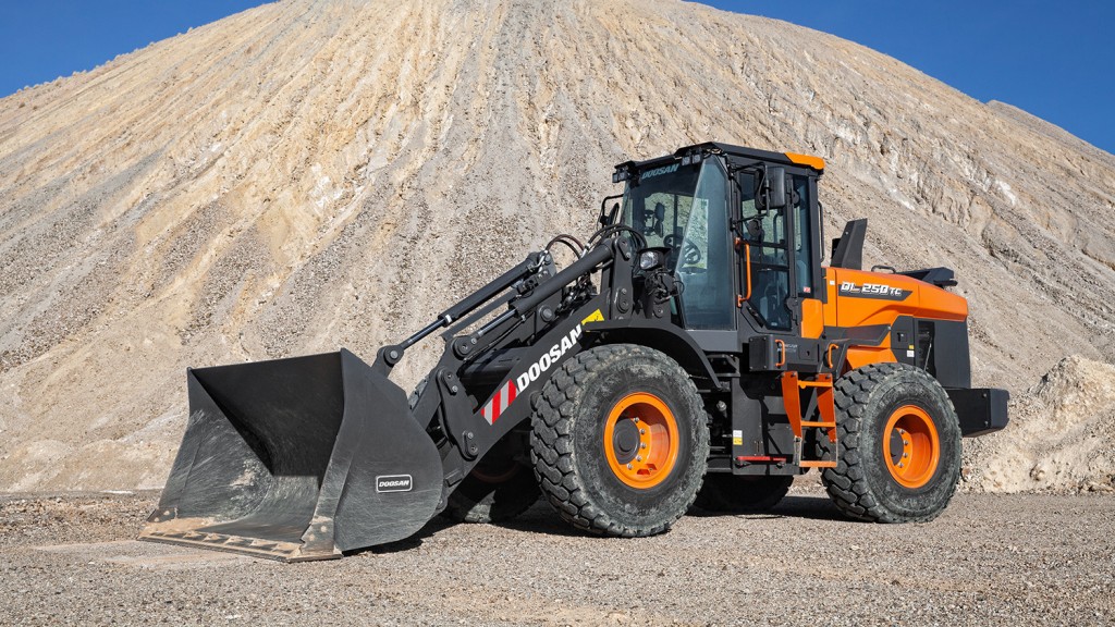 A wheel loader in front of a large gravel pile