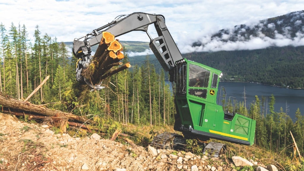 A log loader picks up several logs on a forestry site