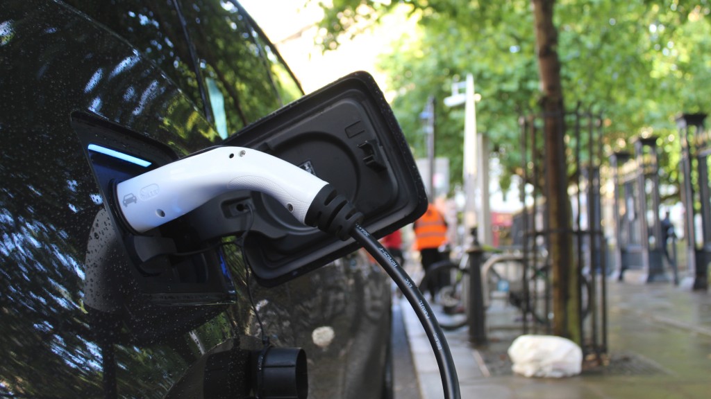 An electric vehicle is charging while parked on the side of a road