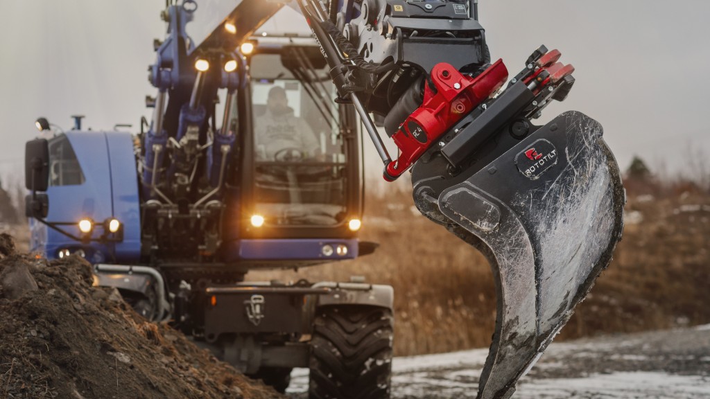 A wheeled excavator uses a tiltrotator in a job site