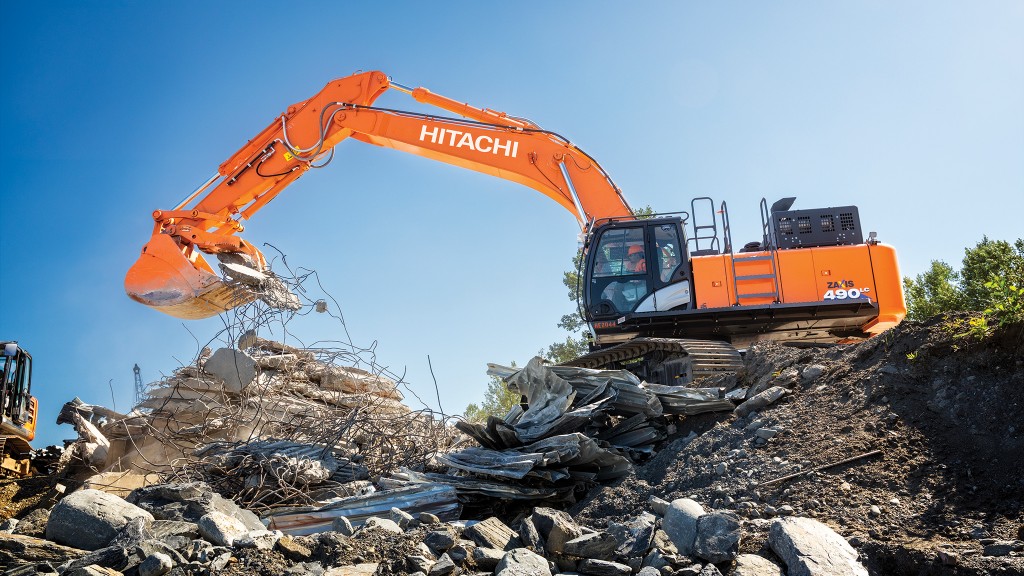 An excavator lifts up demolition waste
