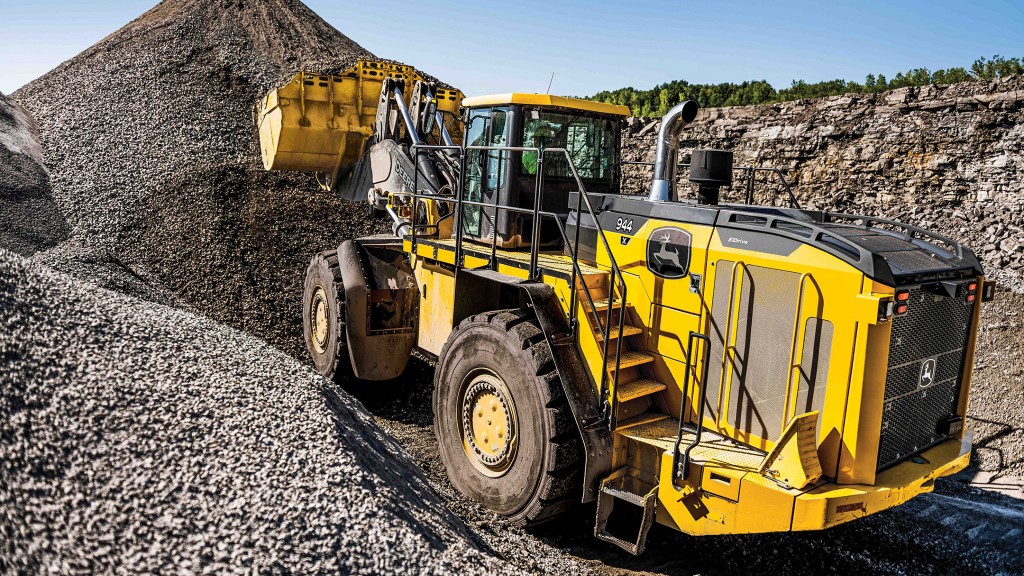 A wheel loader picks up a bucket full or rocks from a mound