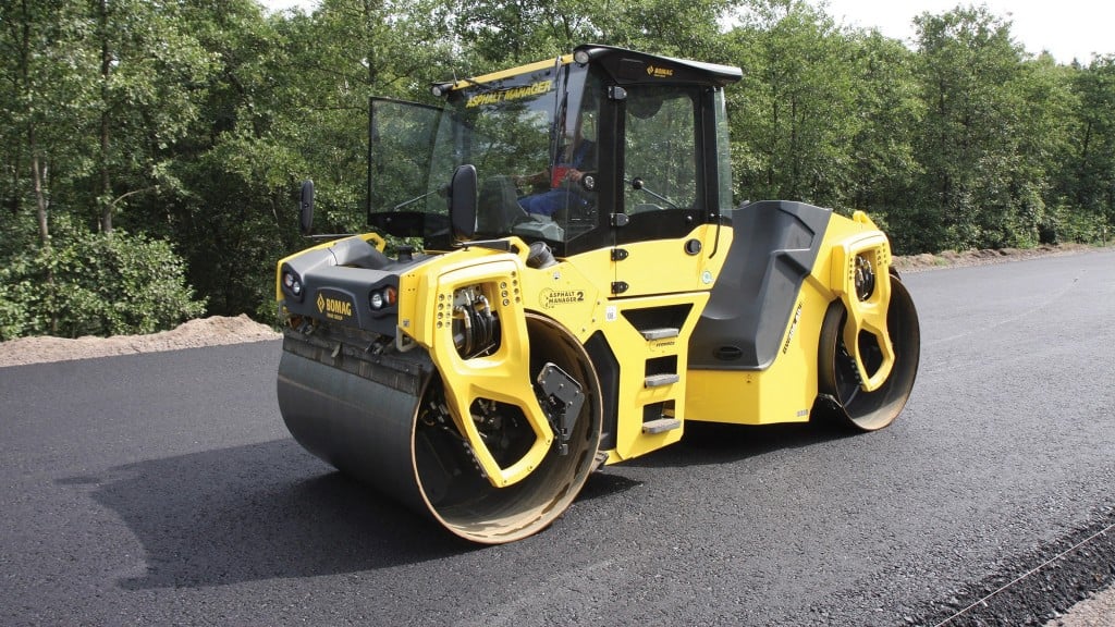 A tandem roller compacts asphalt on a road-in-progress