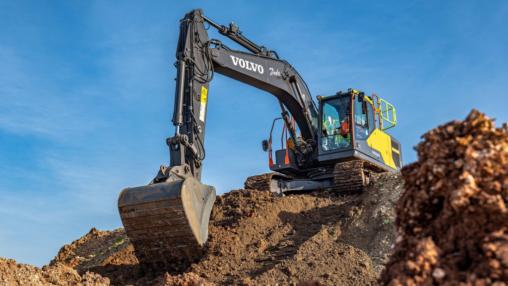 An excavator is about to collect dirt from a hill